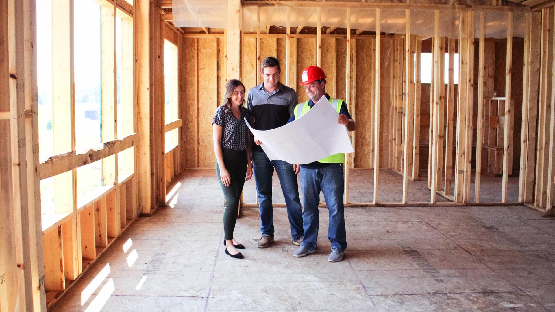image of couple reviewing plans in side a framed home with a Robert Thomas Homes Project Manager